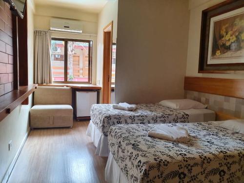 伊瓜苏普萨达松豪梅佛兹酒店的酒店客房,配有两张床和椅子