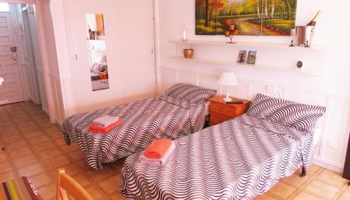 美洲海滩Studio in perfect location的客房设有两张床和一张带台灯的桌子。