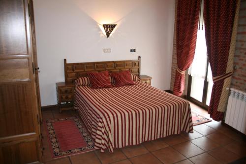 费尔莫塞列Hotel Rural La Enoteca del Marques的一间卧室配有一张带红色枕头的大床
