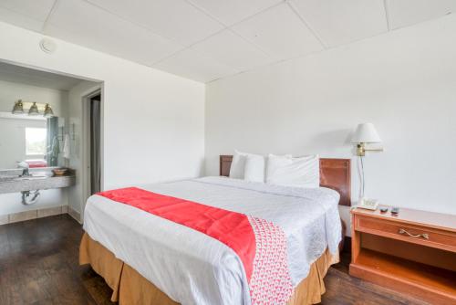 圣安东尼奥OYO Hotel San Antonio Lackland Air Force Base West的一间卧室配有一张带红白毯子的床