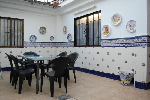 科尔多瓦Casa de David的一间墙上配有桌椅和盘子的用餐室