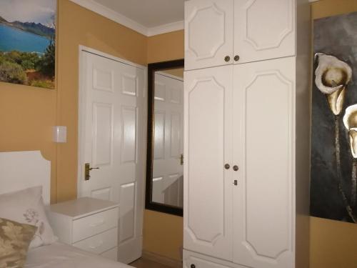 开普敦Onyx on Sycamore的卧室配有白色衣柜和镜子