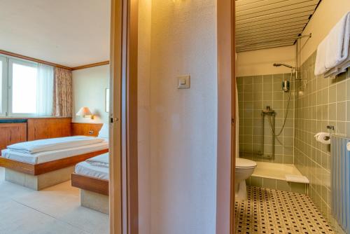 普特加登FF&E Hotel Dania的一间带两张床、淋浴和卫生间的浴室