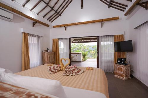 森纳儒日恩吉艾尼小屋的一间卧室配有两张床、一台电视和一张带两个枕头的床。