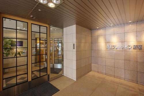 东京Keio Presso Inn Shinjuku的玻璃门的大楼的大堂