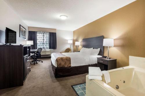 Clare戴斯酒店 - 克莱尔的酒店客房配有一张床和浴缸。