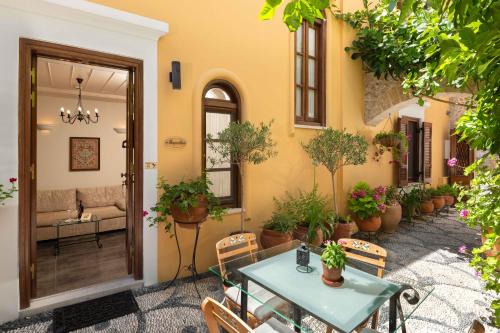 罗德镇罗多斯尼奥霍里精英套房精品酒店的户外庭院配有桌椅和盆栽植物