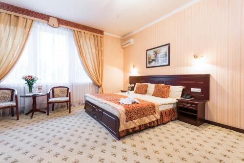 费尔干纳Asia Hotel Fergana的酒店客房带一张床、一张桌子和椅子