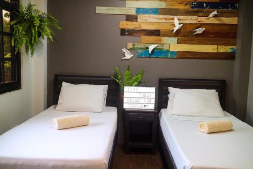 公主港Hostel Privado的两张睡床彼此相邻,位于一个房间里