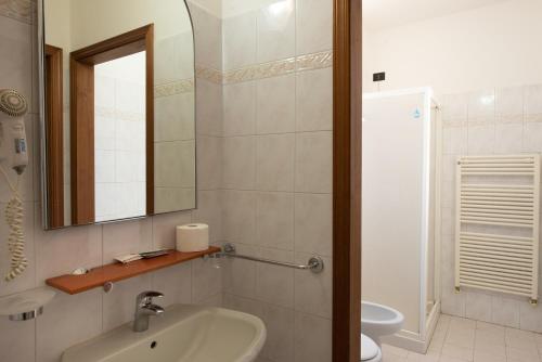 博洛尼亚Hotel Fattori的一间带水槽、镜子和卫生间的浴室
