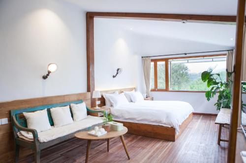 杭州杭州蜜桃小院的一间卧室配有一张床、一张沙发和一个窗口