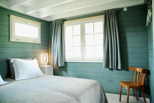 HeerdeBuitenhuisje B&B De Veldweg的蓝色的卧室设有床和窗户