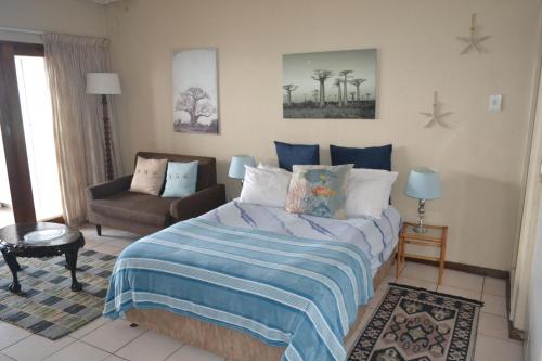 马盖特Ithaca Beach Resort的一间卧室配有一张床和一个沙发