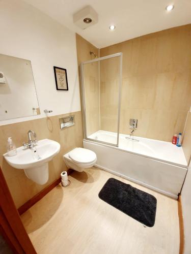 滨海绍森德Southend Ground Floor Apartment with Parking的一间带水槽、浴缸和卫生间的浴室