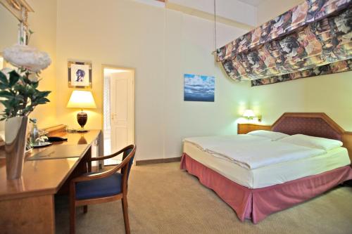 科隆维克托亚酒店的配有一张床和一张书桌的酒店客房