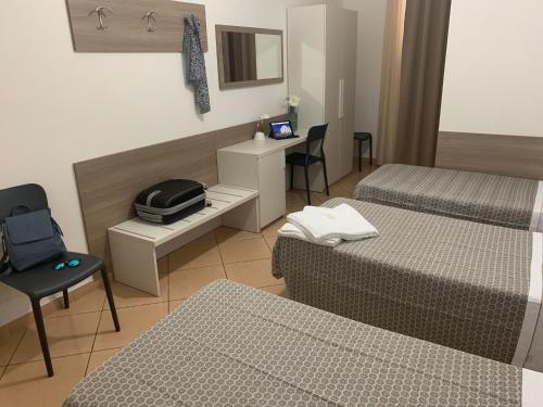 米兰赛洛酒店的酒店客房,设有两张床和一张桌子及椅子