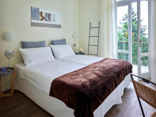 加尔达湖滨埃尔伯格加尔尼莫雷蒂别墅酒店的卧室设有一张白色大床和一扇窗户。