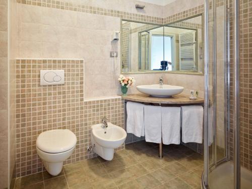 加尔达湖滨埃尔伯格加尔尼莫雷蒂别墅酒店的一间带水槽、卫生间和镜子的浴室