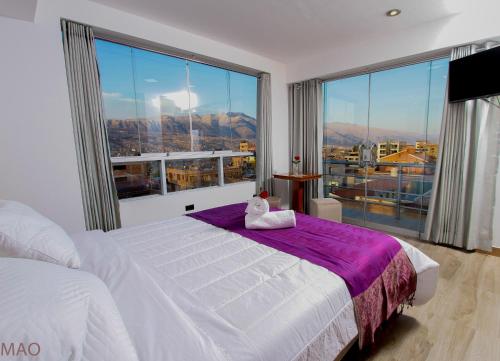 库斯科Latinos House Cusco的卧室设有白色的床和大窗户