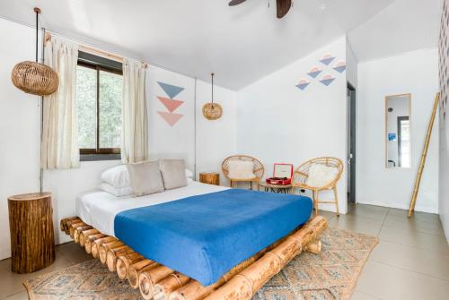 塔马林多Selina Tamarindo的一间卧室配有一张带蓝色毯子的大床
