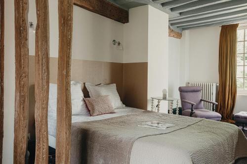 吉维尼乐达米蒂基韦尔尼住宿加早餐旅馆的一间卧室配有一张床和一张紫色椅子