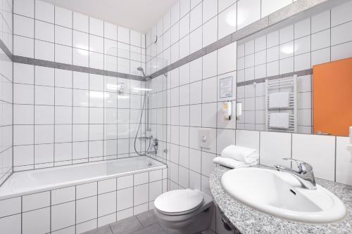 肯普滕斯玛特汽车旅馆的浴室配有盥洗盆、卫生间和浴缸。