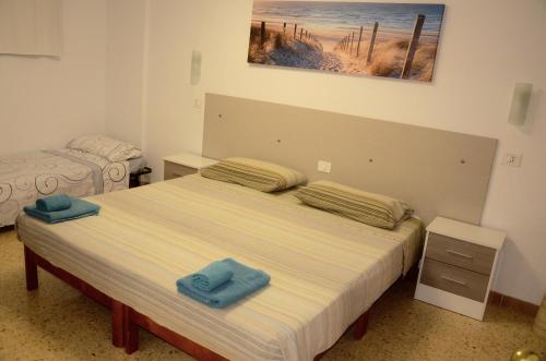 英格兰海滩Apartamento Garland Agaete Parque的一间卧室配有一张带2条蓝色毛巾的床
