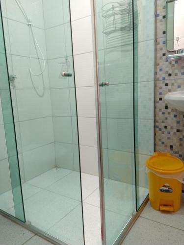 马卡帕Chalé Quintal Amazon的带淋浴和黄色垃圾桶的浴室