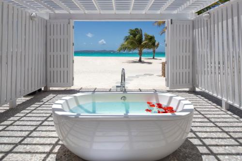Palm IslandThe Palm Island Resort - All Inclusive的海滩上的白色浴缸享有美景。