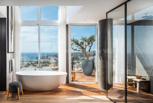 阿德耶Avitan Premium & Luxury Villas的带浴缸的浴室,享有海景。