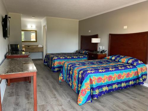 纽波特纽斯Motel 6 Newport News, VA – Fort Eustis的酒店客房设有两张床和一张桌子。