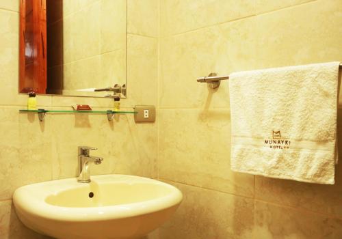 塔克纳Munayki Hotel的浴室配有盥洗盆、镜子和毛巾