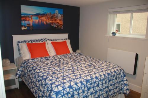 温哥华HiddenGem-private modern suite on trendy Main St的卧室配有一张床,墙上挂有绘画作品