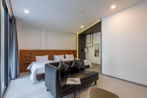 曼谷里诺酒店的酒店客房,配有床和沙发