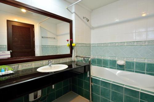 查汶苏梅岛第一酒店的浴室配有盥洗盆、镜子和浴缸