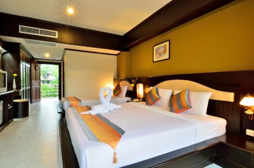 查汶苏梅岛第一酒店的一间卧室配有两张带白色床单的床
