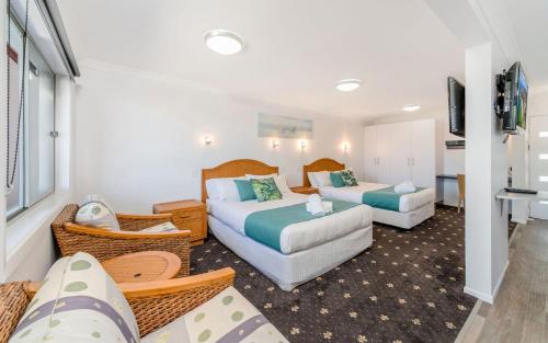 扬巴Adrift Apartments的酒店客房,设有两张床和一张沙发