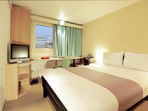塞图巴尔塞图巴尔宜必思酒店的酒店客房设有一张大床和一台电视。
