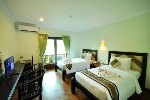 蒲甘Bagan Wynn Hotel的酒店客房设有两张床和一个阳台。