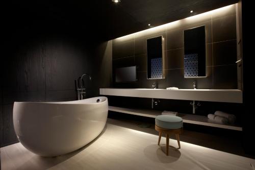 台南台南老爷行旅的浴室配有大型白色浴缸和水槽