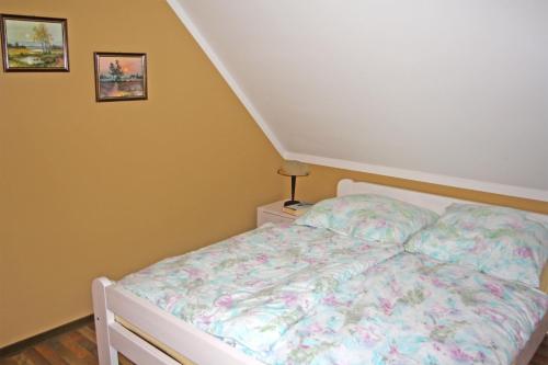 卡尔斯哈根Ferienwohnungen Karlshagen USE 3010的一间卧室配有一张带花卉棉被的床