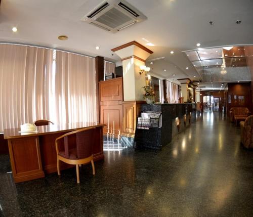 诗巫Kawan Hotel的大房间设有大堂,配有酒吧和椅子