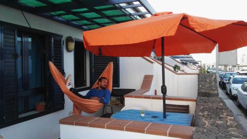 宏达海滩Papá Totë的坐在吊床上伞下的人