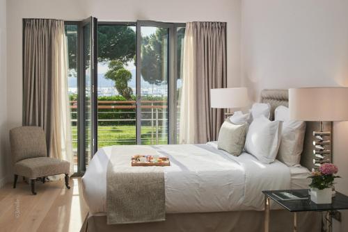 戛纳FRGK"Contemporary Villa on the Croisette with Stunning Sea Views & Private Pool!!!的卧室设有白色的床和大窗户