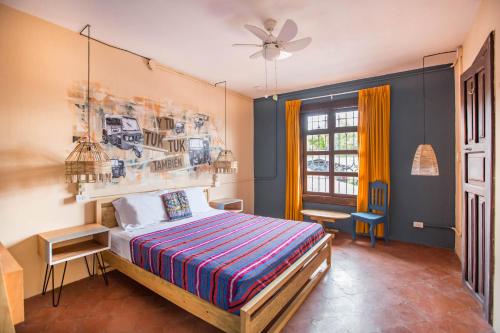 危地马拉安地瓜Selina Antigua的一间卧室配有一张床和吊扇
