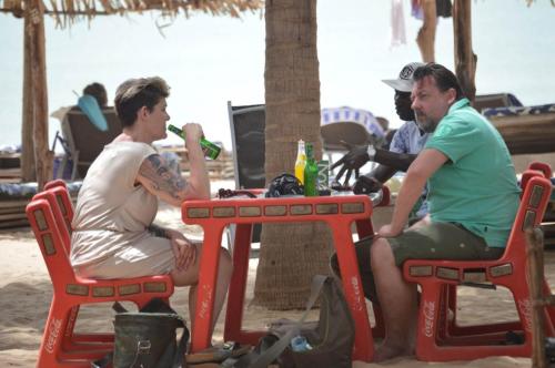SanyangRainbow beach resort的坐在海滩桌子上的两个人