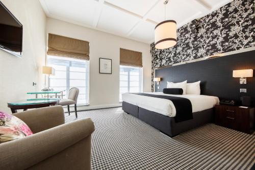 阿姆斯特丹诺丁山精品酒店的酒店客房配有床、沙发和桌子。