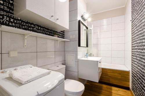 华沙Gama Home Kondratowicza18的白色的浴室设有卫生间和水槽。