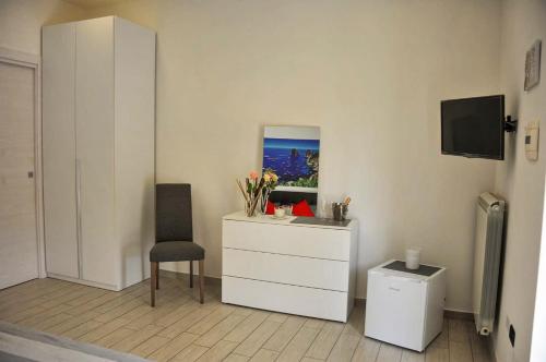 庞贝B&B Le due Rose (Pompei)的一间设有梳妆台、椅子和电视的房间