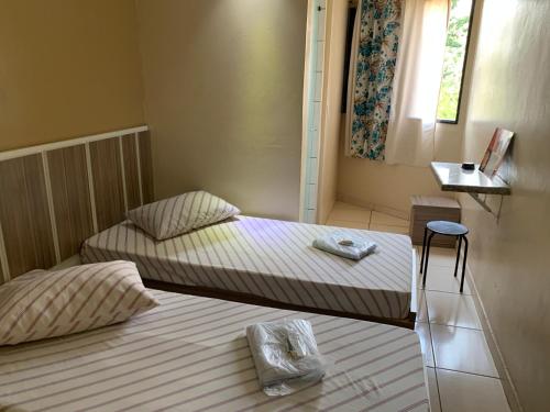 南圣卡埃塔诺HOTEL FLOR DO AMAZONAS (ADULTS ONLY)的带窗户的客房内设有两张单人床。